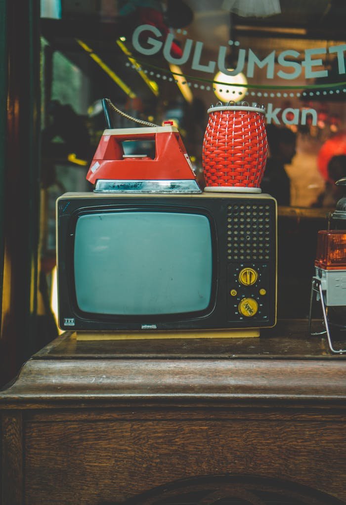 why-choose-us Old school TV with vintage iron and wicker lamp, nostalgic decor vibe.